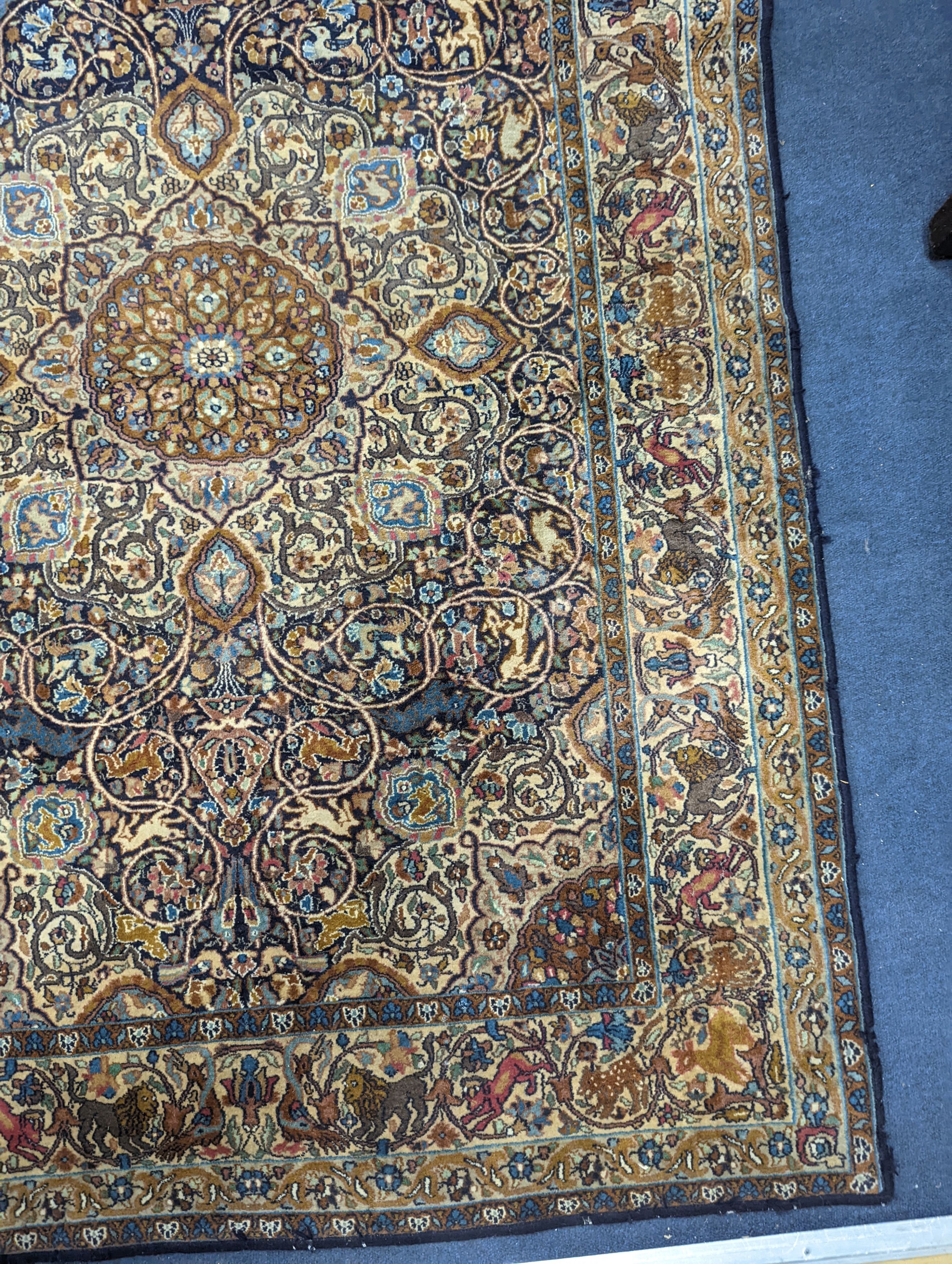 A Kashan blue ground rug woven with animals. 187x125cm.